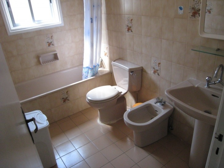 The family bathroom of the property, with a sink, a toilet, a bide, and a bathtub