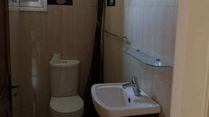 Guest toilet area with a WC , a sink, and marble wall and floor tiles