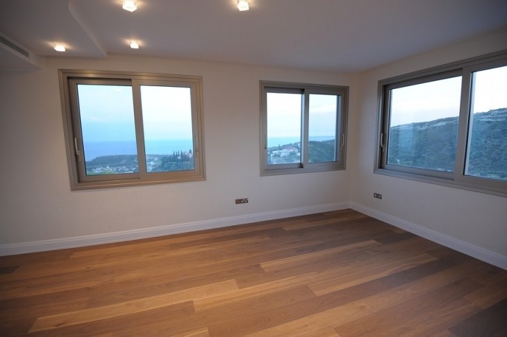 The bedroom has three (3) windows around it showing the mountain view behind, and a parquet floor.
