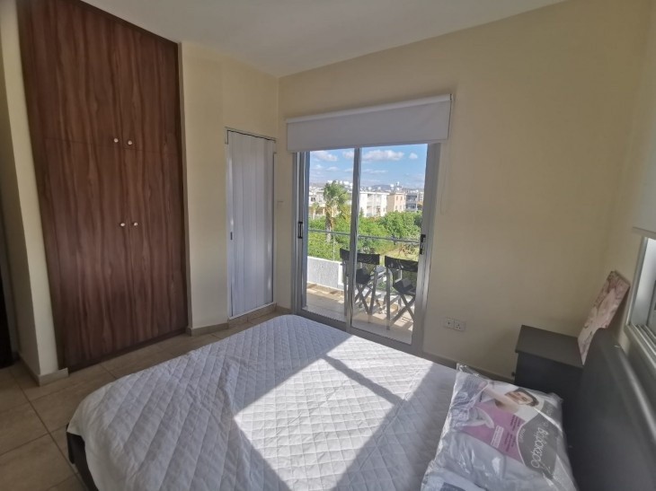Double bed with mattress, an ensuite shower and a window leading to the bedroom balcony