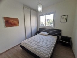 Picture of the second bedroom, having one double bed, bedside tables, cupboards, and a/c unit.