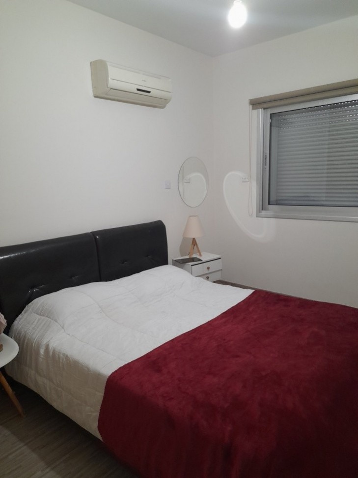 Double bed with bedside table, air conditioning unit, double glazed windows and shutters