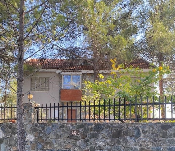 Picture of the exterior of the detached house in Trimiklini, the house is in the woods.