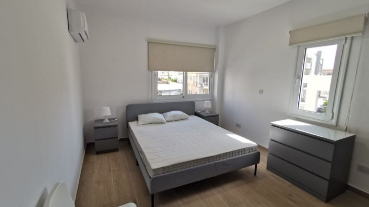 Bedroom furniture including a double bed, bedside tables, air conditioning unit and roller blinds