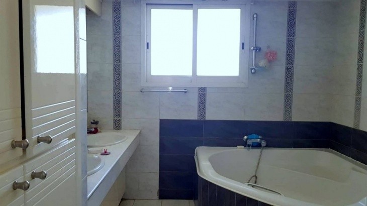 Picture of one of the two bathrooms, having a large bathtub, two sinks, and spacious cupboards.