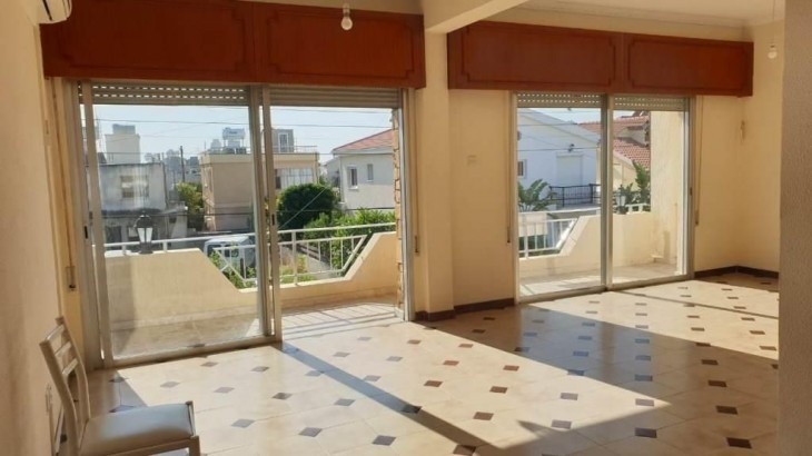 Picture the unfurnished living room and the covered balcony with town view.